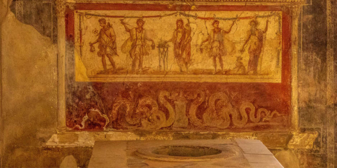 Fresque antique préservée dans un Thermopolium à Pompéi, illustrant des personnages et des serpents au-dessus d'un comptoir de restauration avec une ouverture circulaire.