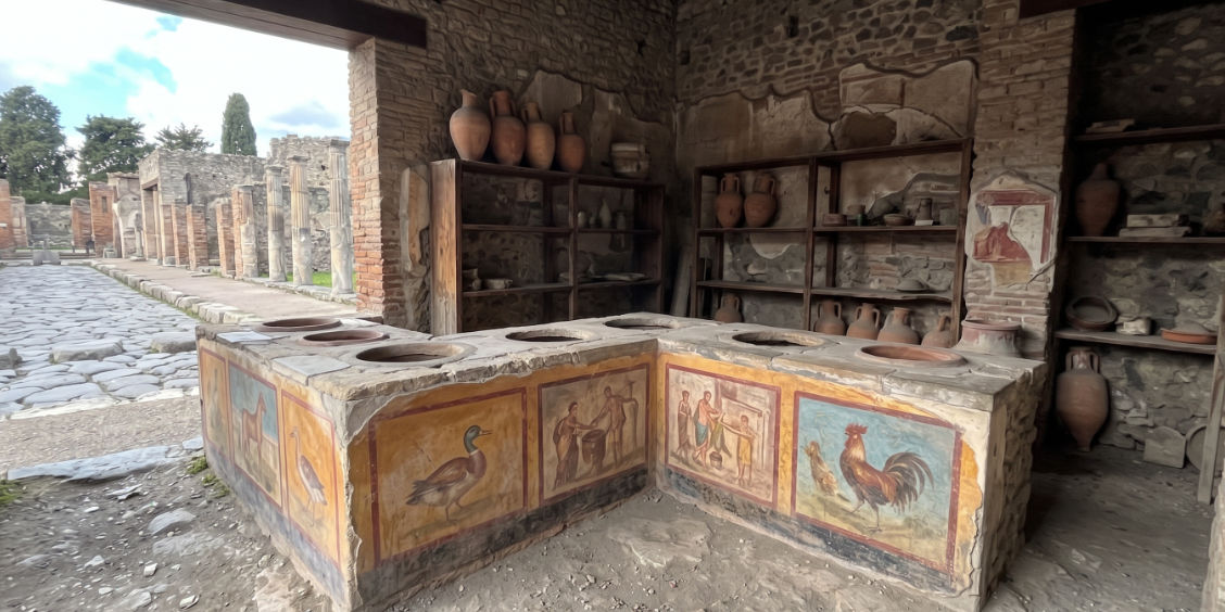 Comptoir orné de fresques d'un thermopolium dans les fouilles de Pompéi, l'ancêtre antique de la restauration rapide.