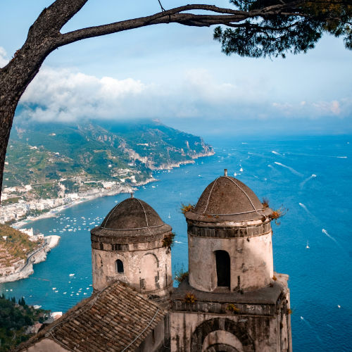 Détail des tours historiques aux coupoles mauresques de la Villa Rufolo avec vue plongeante sur la Côte Amalfitaine.