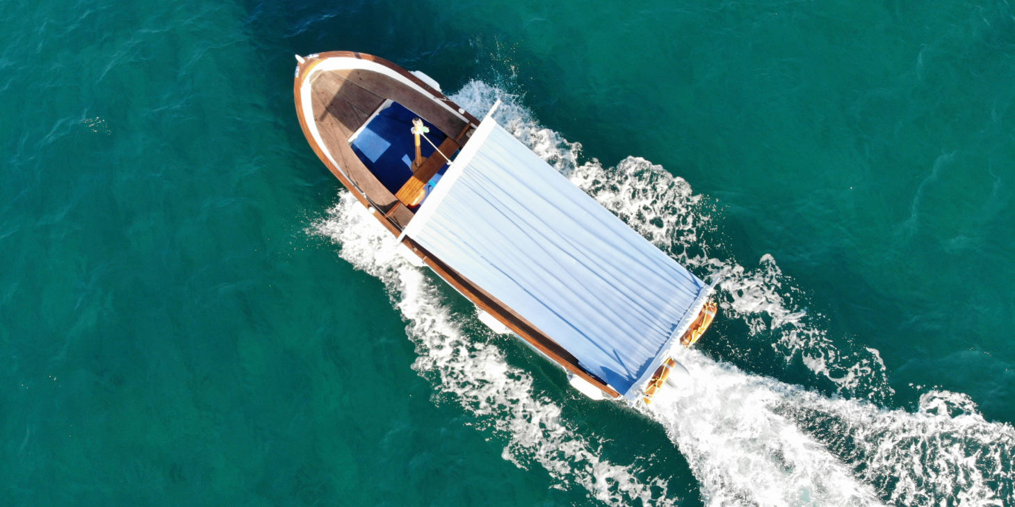 Vue aérienne d'un bateau traditionnel naviguant sur l'eau turquoise.