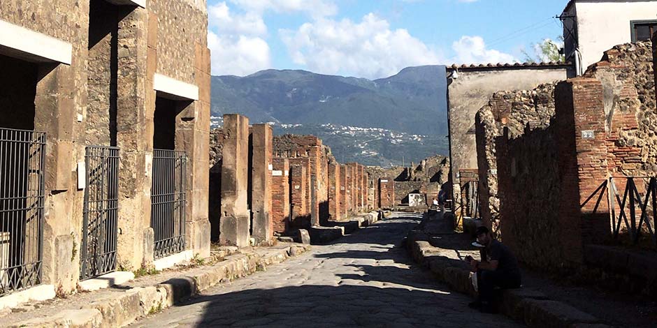 Ruelle historique de Pompéi avec vue sur les montagnes.