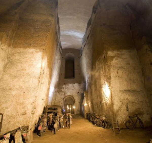 Galeries souterraines du Tunnel Bourbon à Naples avec vestiges historiques et anciens véhicules abandonnés.