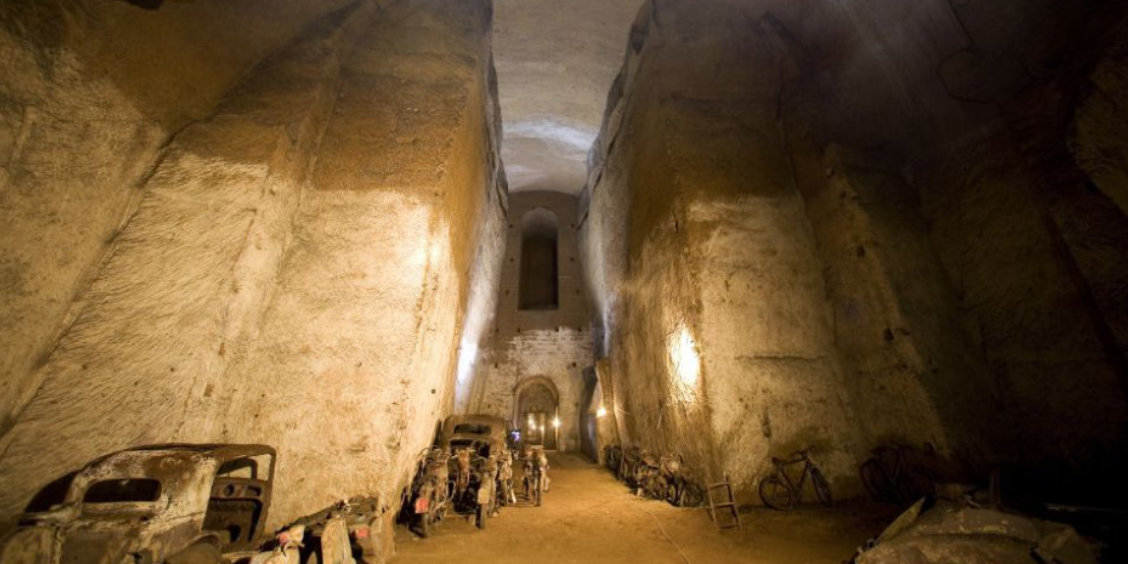 Galeries souterraines du Tunnel Bourbon à Naples avec vestiges historiques et anciens véhicules abandonnés.