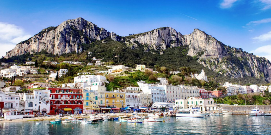 Port de Marina Grande à Capri avec ses maisons colorées, ses bateaux et ses hautes falaises rocheuses.
