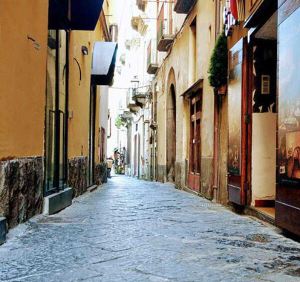 Via Pietà à Sorrente avec ruelle pavée, façades anciennes et boutiques du centre historique.