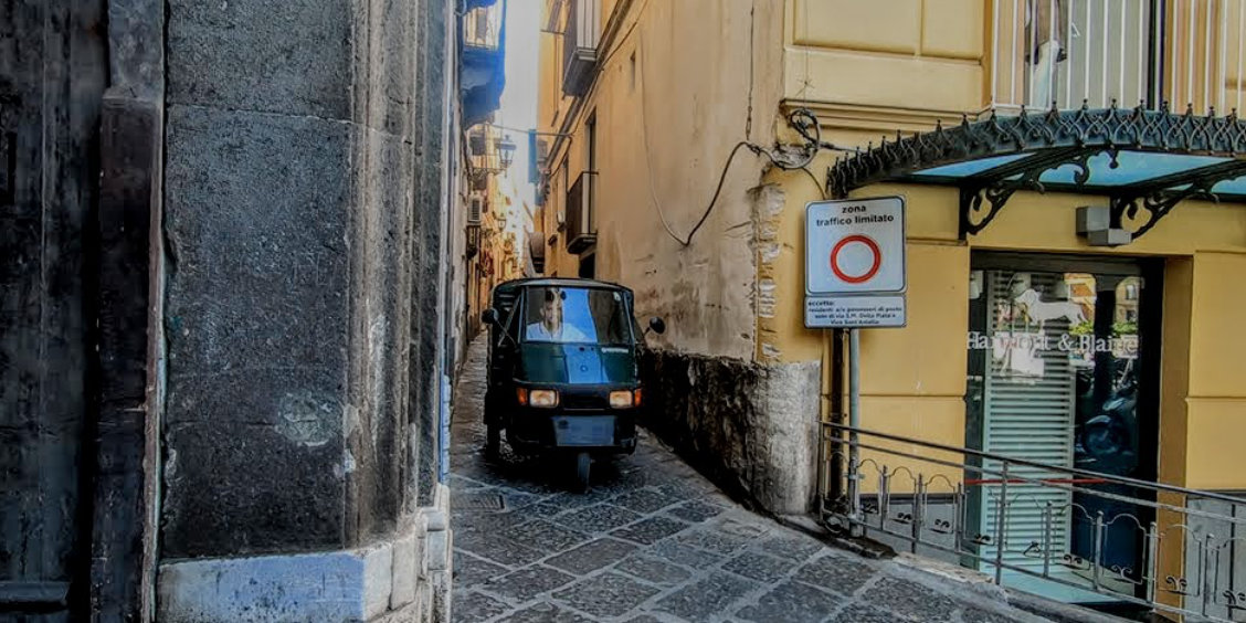 Via Pietà à Sorrente avec ruelle étroite, ape car et panneau de zone à trafic limité.