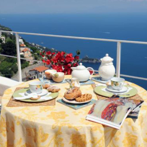 Petit-déjeuner sur le balcon de la Villa Aramara à Furore avec vue panoramique sur la côte.