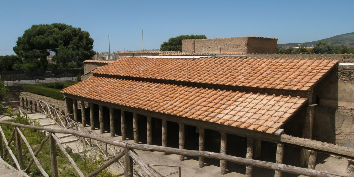 Architecture de la Villa des Mystères à Pompéi montrant sa colonnade et son toit en tuiles rouges.