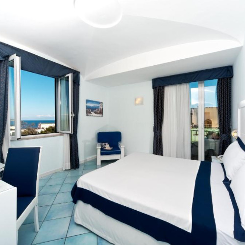 Chambre élégante aux tons bleu et blanc offrant une vue sur la mer à la Villa Durelli.