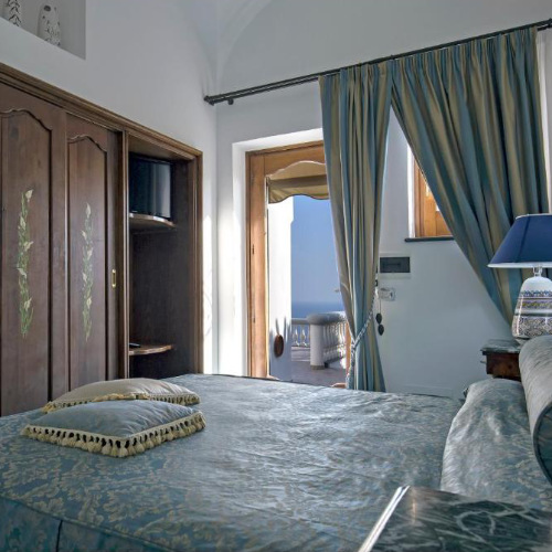 Chambre raffinée avec balcon vue mer et décoration classique à Villa Elena.
