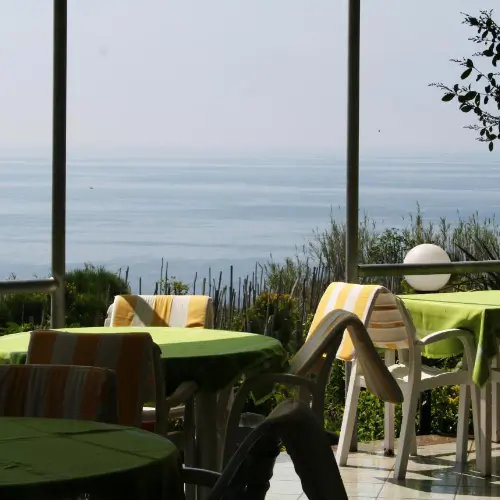 Terrasse panoramique avec tables de restaurant face à la mer.