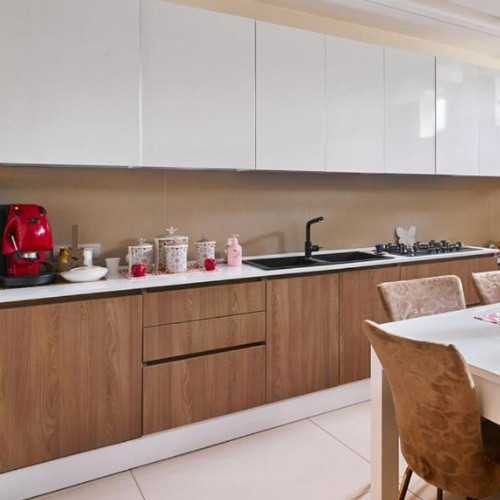 Cuisine contemporaine de la Villa Nadia avec des meubles en bois et une machine à café rouge.