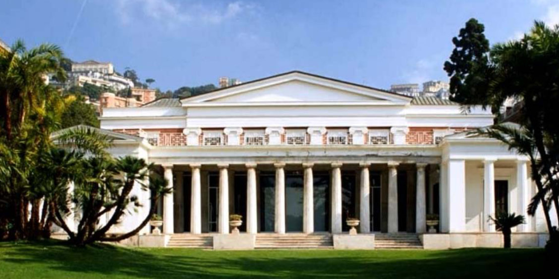 Façade néoclassique de la Villa Pignatelli à Naples avec colonnade monumentale et jardin verdoyant.