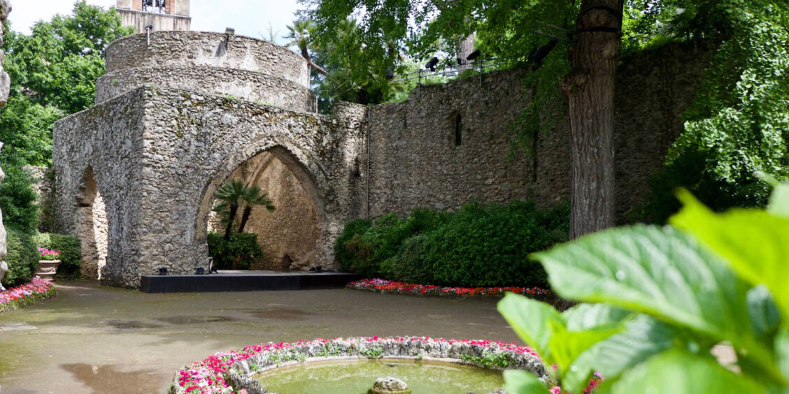 Villa Rufolo à Ravello avec jardin fleuri, arc en pierre et architecture médiévale sur la Côte Amalfitaine.