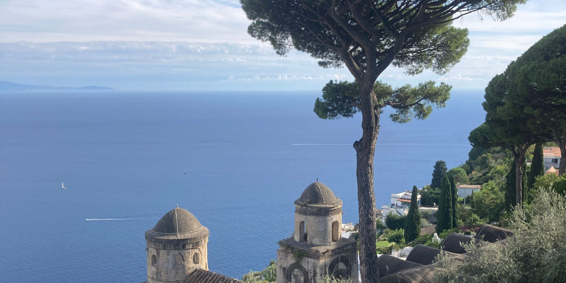 Vue panoramique depuis la Villa Rufolo à Ravello avec les coupoles, le pin parasol et la mer Méditerranée en arrière-plan.