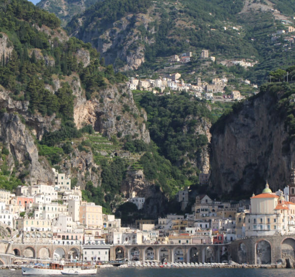 Vue depuis la mer sur le village d'Atrani dominé par les falaises et les hauteurs perchées de Ravello.