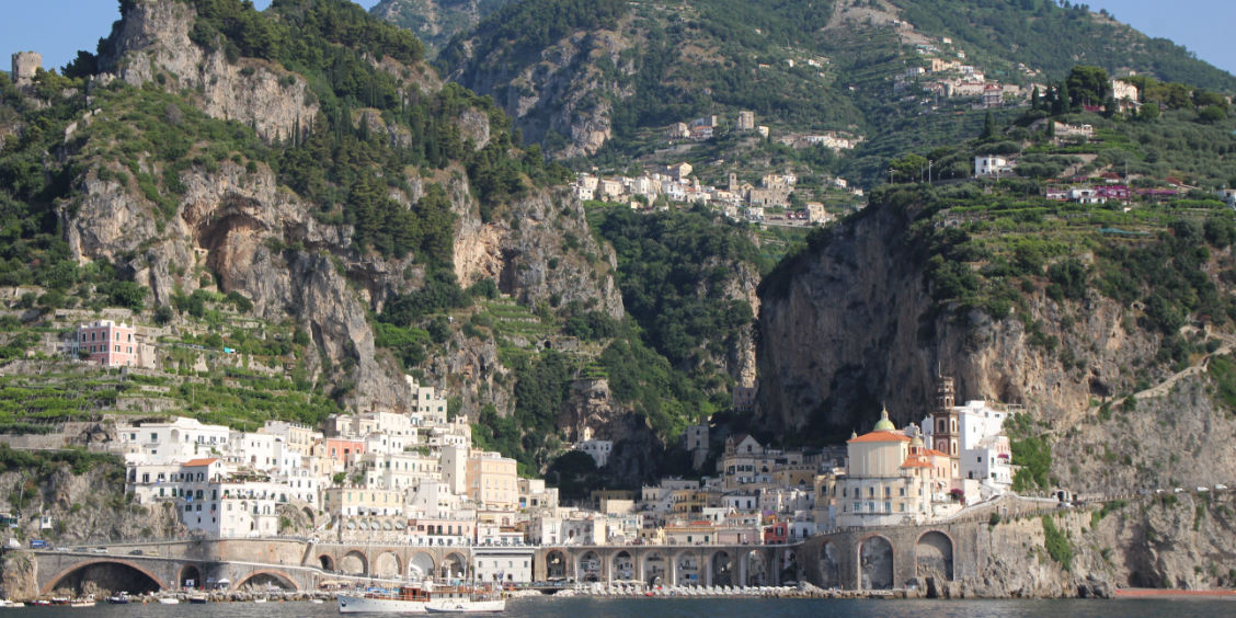 Vue depuis la mer sur le village d'Atrani dominé par les falaises et les hauteurs perchées de Ravello.