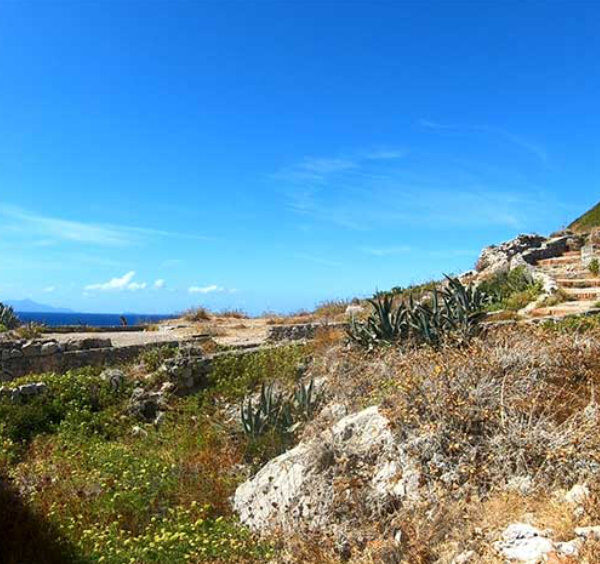 Vestiges de villas romaines près de Sorrente avec sentier côtier, végétation méditerranéenne et mer au loin.