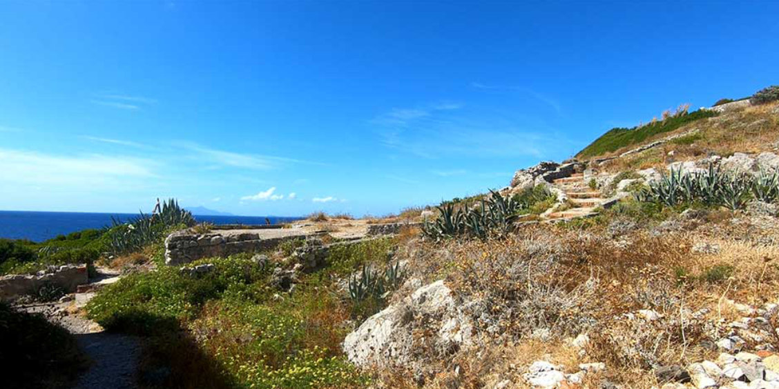 Vestiges de villas romaines près de Sorrente avec sentier côtier, végétation méditerranéenne et mer au loin.
