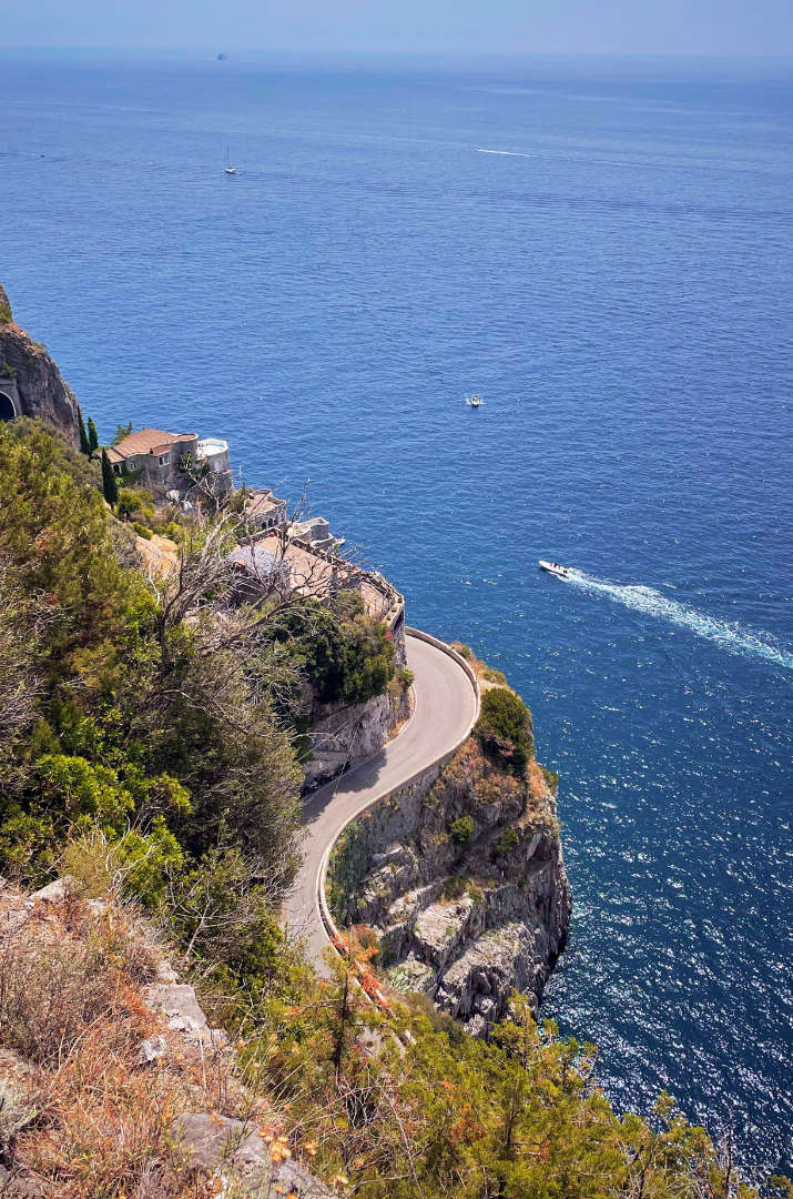 Route panoramique de la Côte Amalfitaine longeant les falaises avec vue sur la mer.