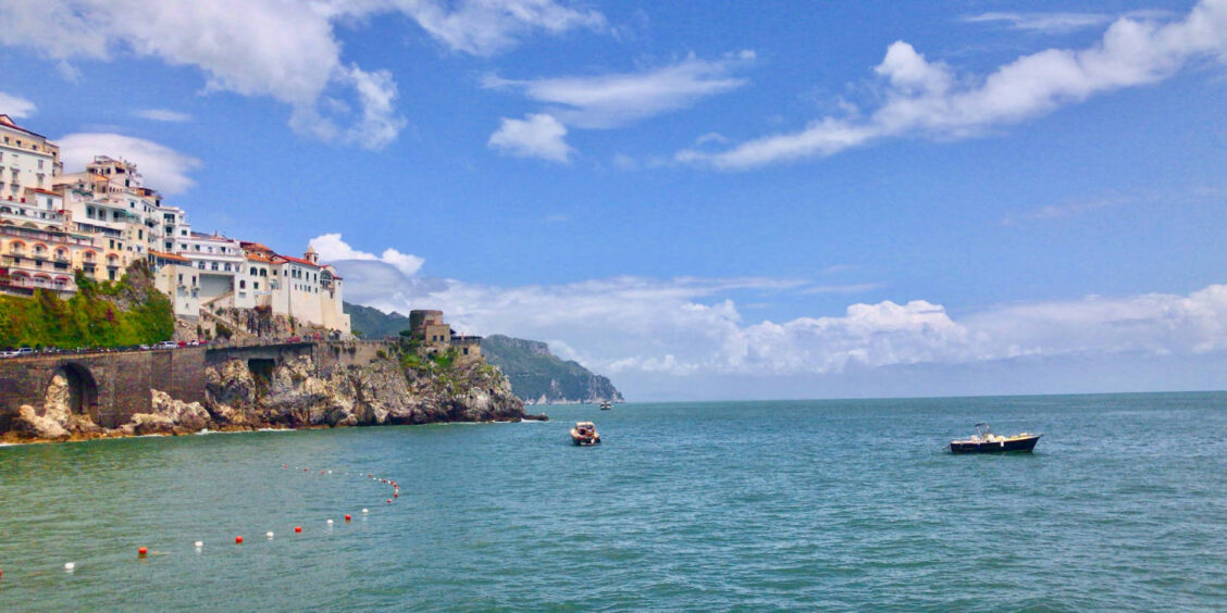 Côte Amalfitaine depuis Sorrente avec village perché, falaises et bateaux sur la mer Méditerranée.