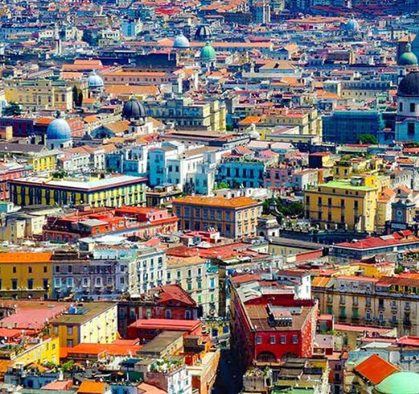 Vue panoramique de Naples avec ses bâtiments colorés, ses églises et ses dômes, illustrant le centre historique de la ville.