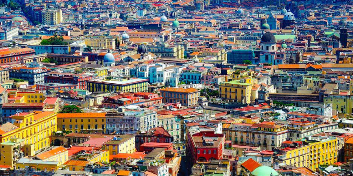 Vue panoramique de Naples avec ses bâtiments colorés, ses églises et ses dômes, illustrant le centre historique de la ville.