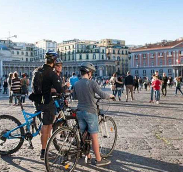 Piazza del Plebiscito à Naples avec cyclistes et vue sur la basilique San Francesco di Paola.