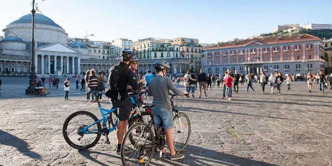 Piazza del Plebiscito à Naples avec cyclistes et vue sur la basilique San Francesco di Paola.