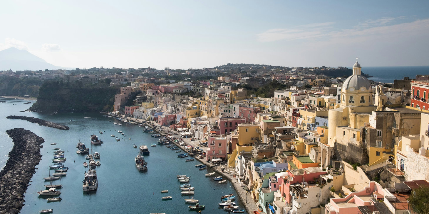 Vue panoramique du port de Corricella à Procida avec ses maisons colorées.