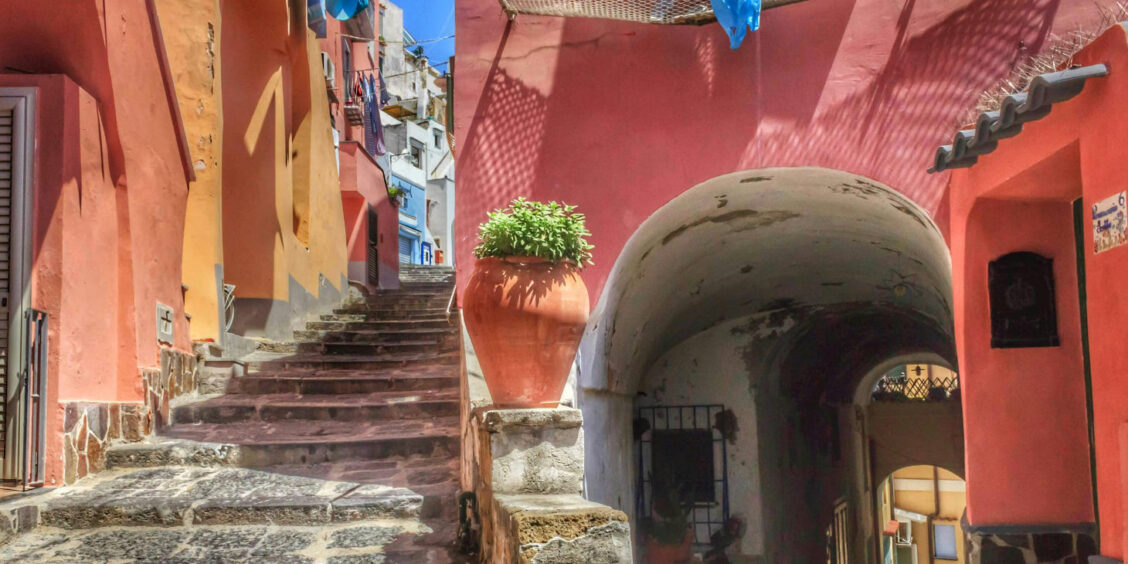 Escaliers et maisons aux murs roses dans les ruelles typiques de Procida, perle de la Campanie.