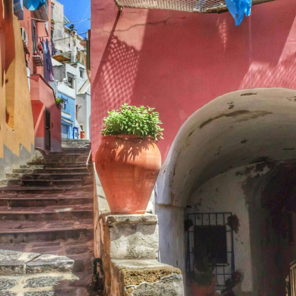 Escaliers et maisons aux murs roses dans les ruelles typiques de Procida, perle de la Campanie.
