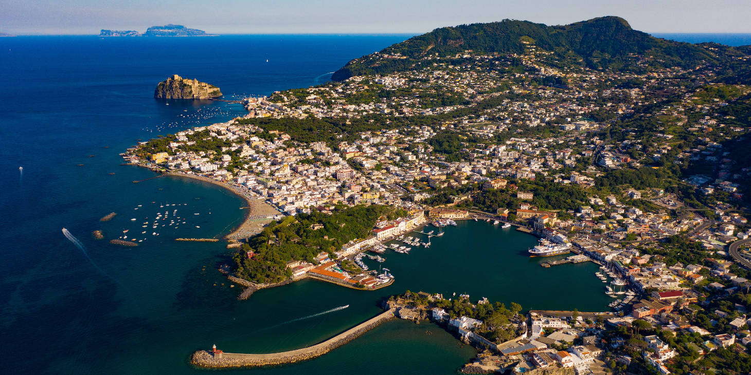 Vue panoramique du port circulaire d'Ischia Porto et du Château Aragonais au loin.