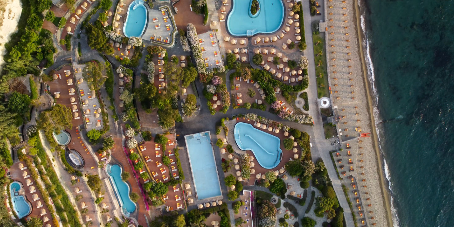 Vue aérienne d'un grand complexe thermal et de ses piscines en bord de mer.